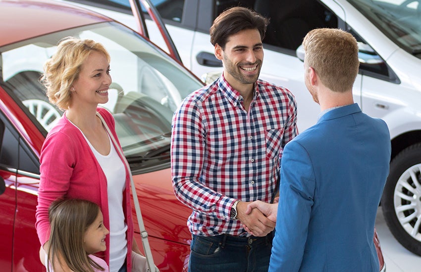 Family talking to car salesperson
